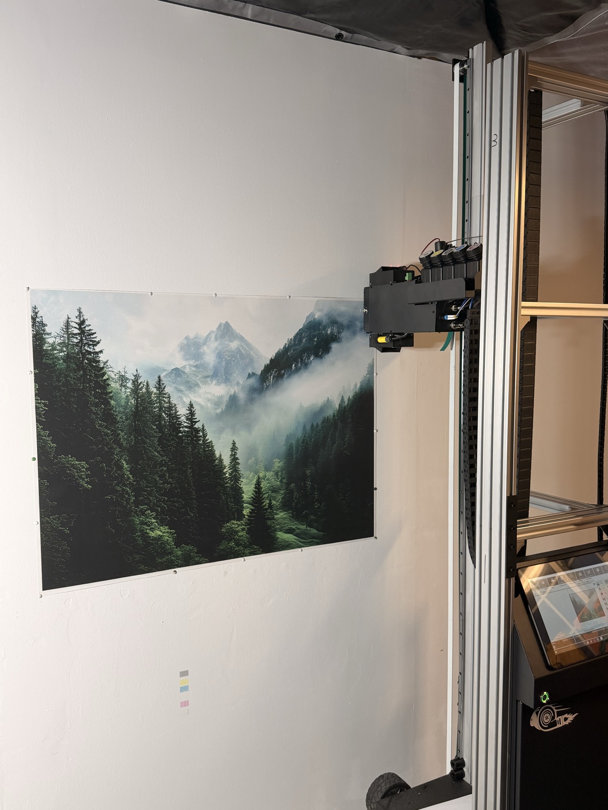 Misty evergreen forest mural on a white wall with the vertical printer beside it